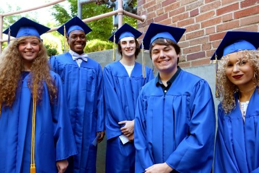 A group of smiling graduates of Visions In Education smiling