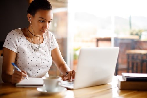 Female student on her laptop working from home on University Prep schoolwork offered by Visions In Education